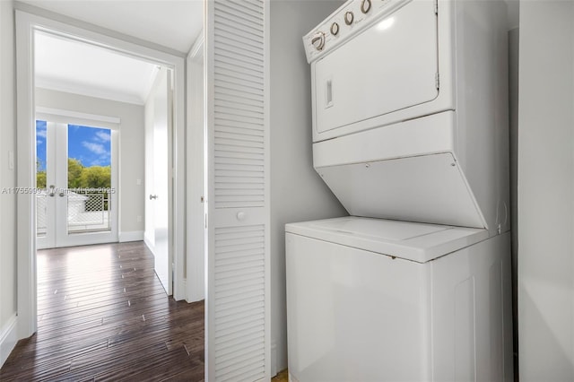 clothes washing area featuring laundry area, baseboards, ornamental molding, dark wood-type flooring, and stacked washing maching and dryer