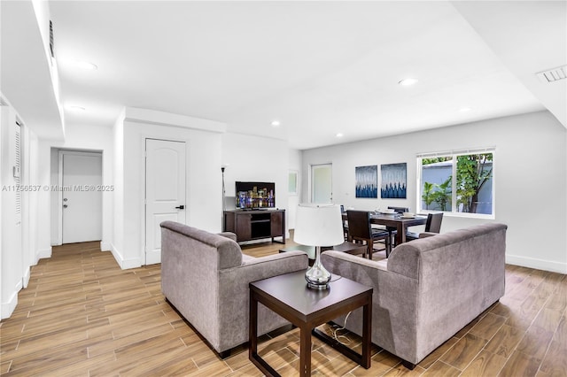 living area with baseboards, recessed lighting, visible vents, and light wood-style floors