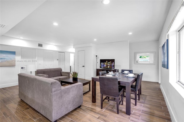 living area with wood tiled floor, baseboards, and recessed lighting