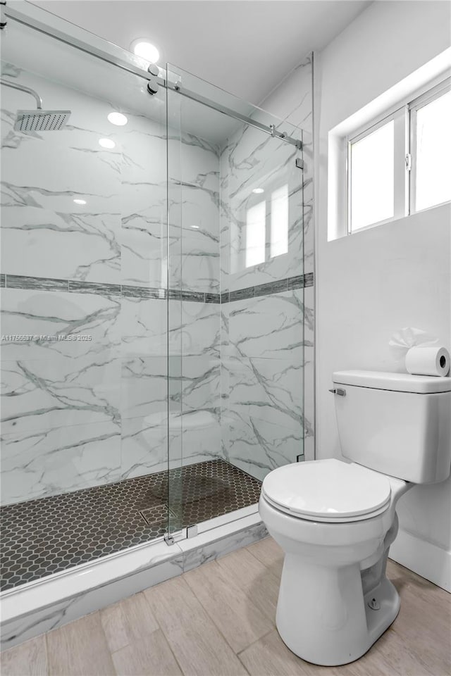 full bathroom with a marble finish shower and toilet