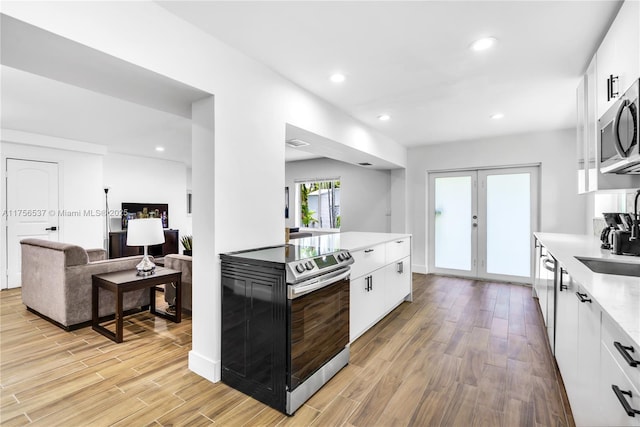 kitchen with french doors, appliances with stainless steel finishes, light wood-style flooring, and white cabinets