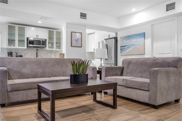 living area featuring recessed lighting, visible vents, and wood finish floors