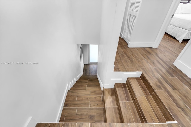 stairs featuring baseboards and wood tiled floor