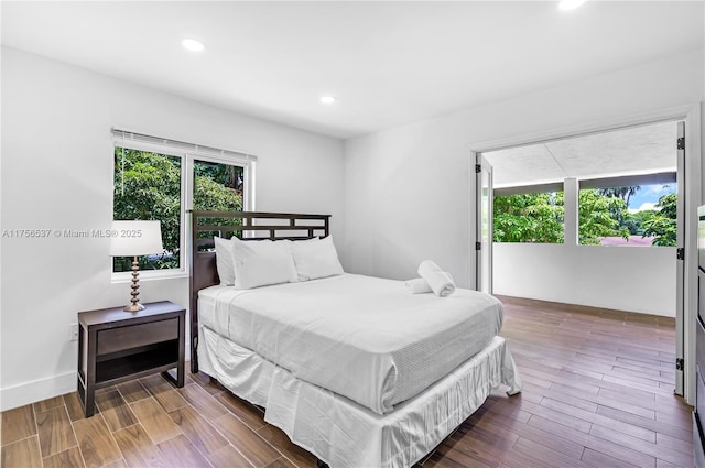 bedroom with baseboards, dark wood finished floors, and recessed lighting