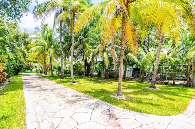 view of property's community with a lawn and fence