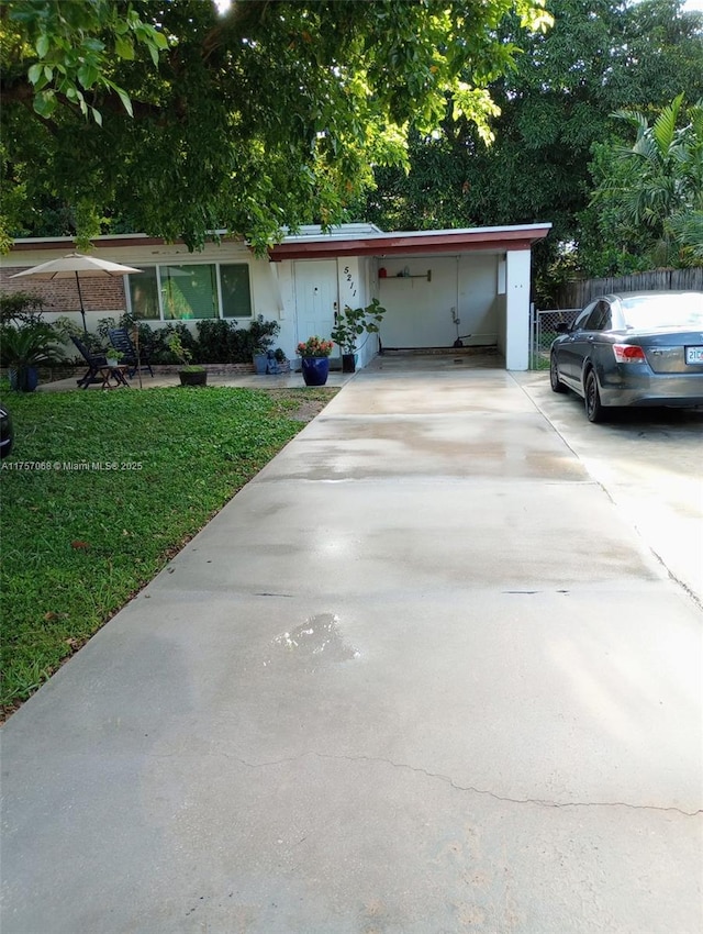 ranch-style home with driveway, a front yard, and fence