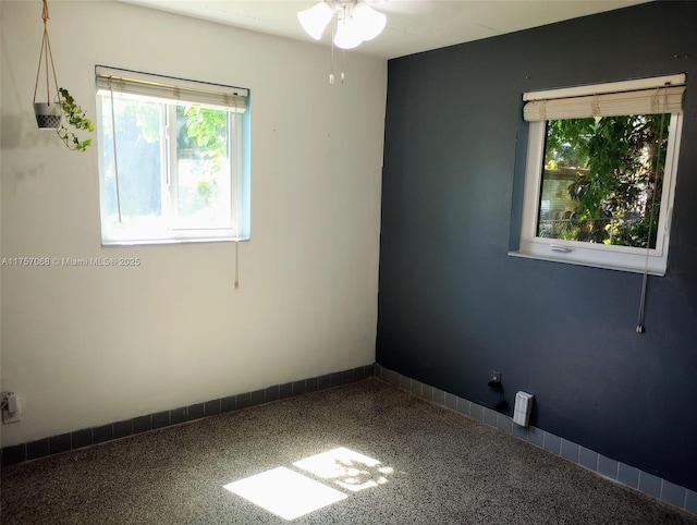 empty room featuring speckled floor and baseboards