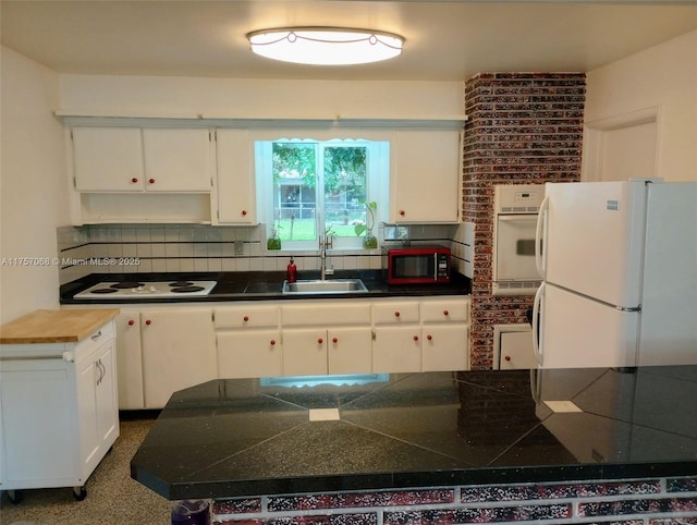 kitchen with white cabinets, white appliances, backsplash, and a sink