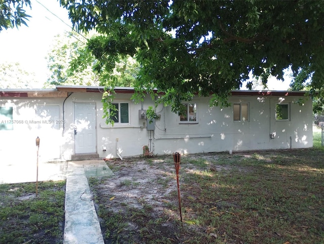 rear view of property featuring stucco siding