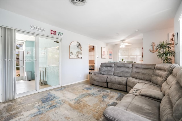 living room featuring a ceiling fan, visible vents, and baseboards