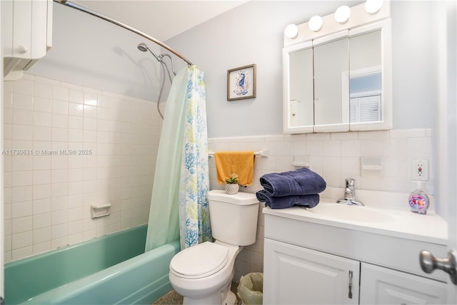 full bathroom featuring toilet, a wainscoted wall, shower / bath combination with curtain, vanity, and tile walls