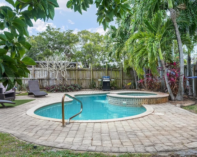 view of pool featuring area for grilling, a patio area, a fenced backyard, and a pool with connected hot tub