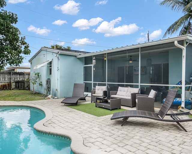 rear view of property featuring a sunroom, a patio area, fence, and stucco siding