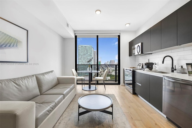 interior space with light wood finished floors, expansive windows, visible vents, and a city view