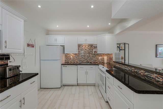 kitchen featuring white appliances, white cabinetry, a sink, and backsplash