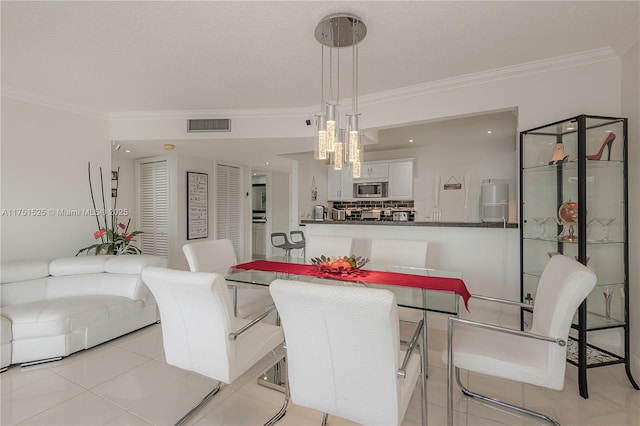 dining space featuring light tile patterned floors, visible vents, and crown molding