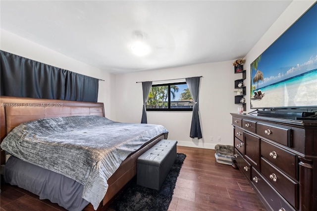 bedroom featuring dark wood-style flooring and baseboards