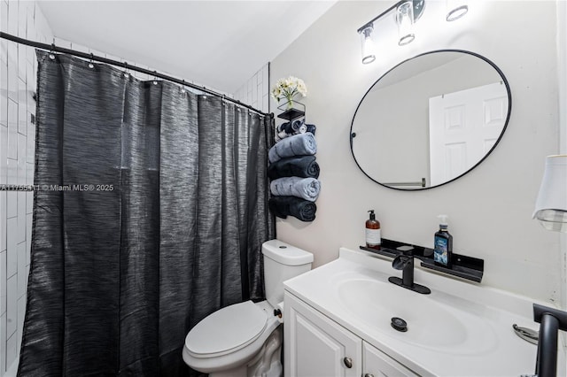 bathroom with a shower with shower curtain, vanity, and toilet