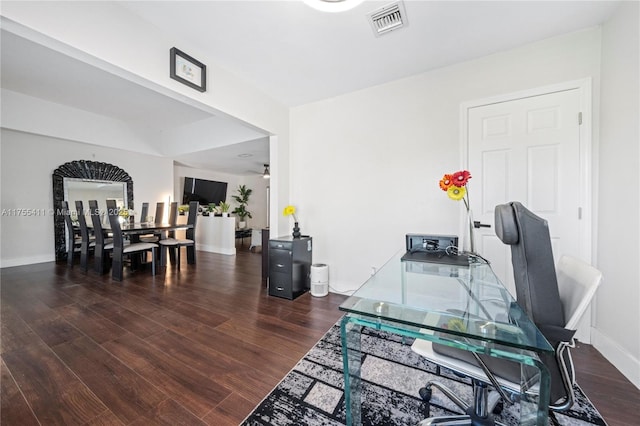 home office with a ceiling fan, visible vents, baseboards, and wood finished floors