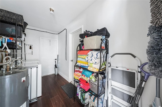 laundry room featuring electric water heater and dark wood finished floors