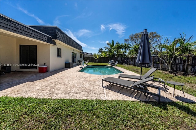 view of swimming pool featuring a fenced in pool, a yard, a fenced backyard, and a patio