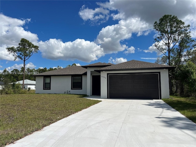 prairie-style home featuring driveway, stucco siding, an attached garage, and a front yard