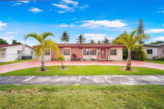 ranch-style home with a front yard, concrete driveway, and a tile roof