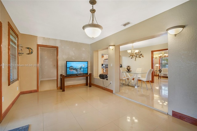 interior space featuring an inviting chandelier, baseboards, visible vents, and tile patterned floors