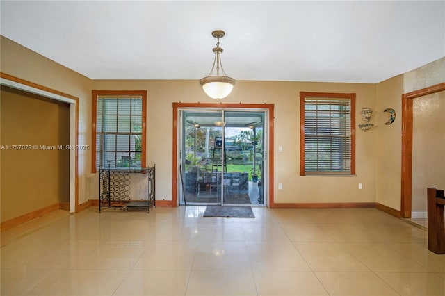 interior space featuring light tile patterned floors and baseboards