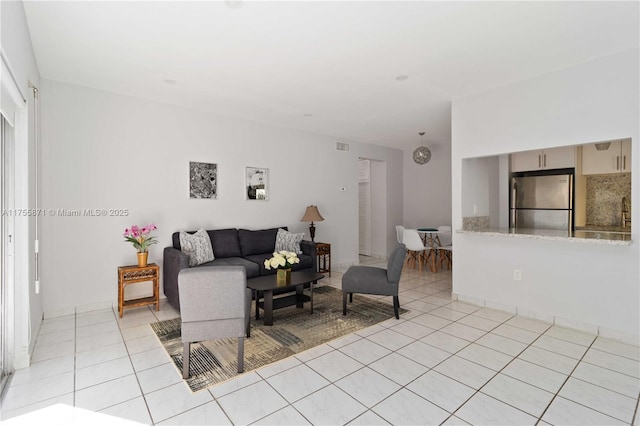 living room featuring light tile patterned floors and visible vents