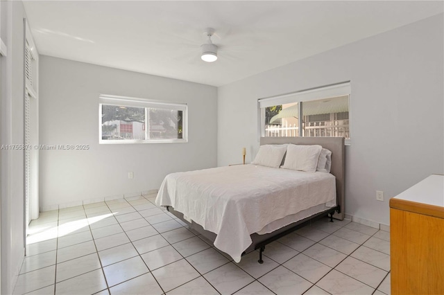 bedroom featuring light tile patterned flooring, a ceiling fan, and baseboards