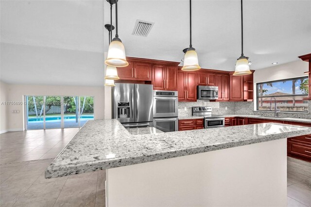 4840 SW 141st Ave, Miami, FL 33175 - kitchen featuring reddish brown cabinets, tasteful backsplash, visible vents, appliances with stainless steel finishes, and a sink