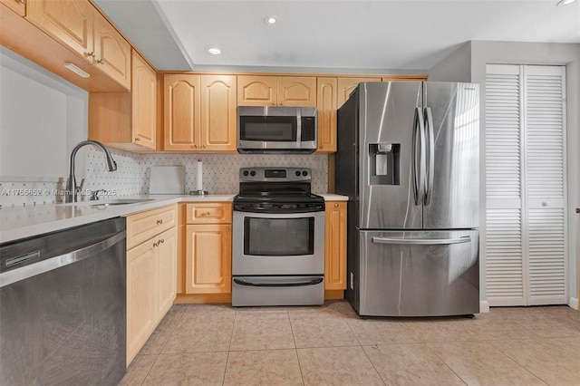 kitchen featuring light brown cabinetry, appliances with stainless steel finishes, a sink, and light countertops