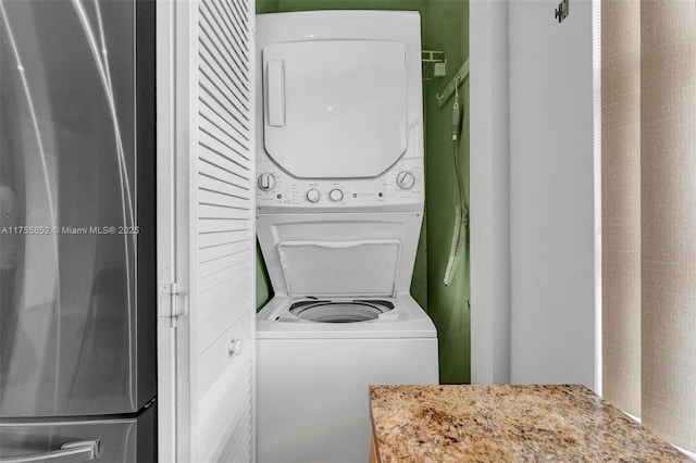 laundry room with stacked washer / dryer and laundry area