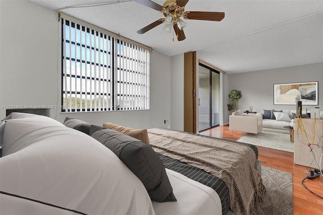 bedroom with ceiling fan, multiple windows, and wood finished floors