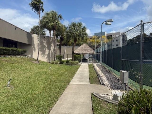 view of property's community featuring a gate, fence, and a lawn