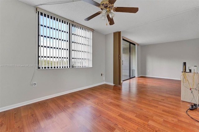 unfurnished room featuring a healthy amount of sunlight, baseboards, and wood finished floors