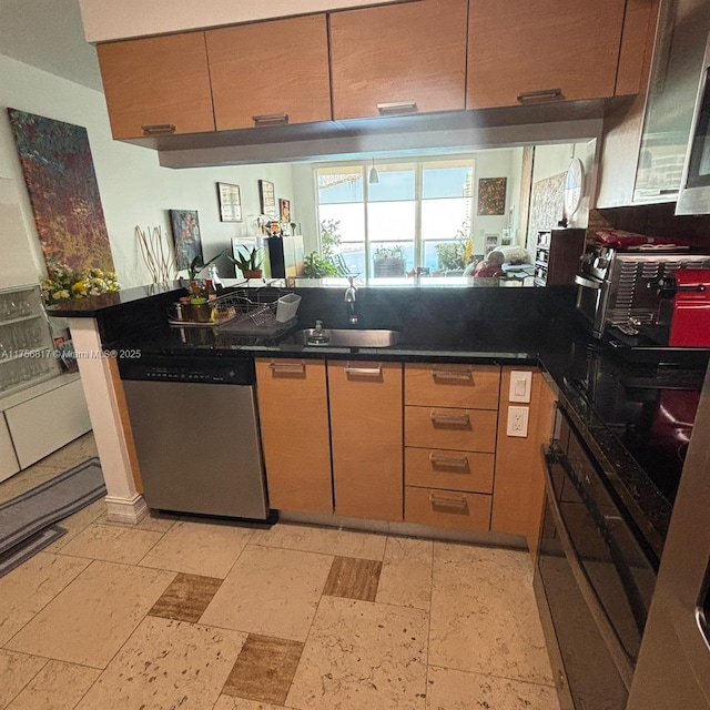 kitchen with a peninsula, a sink, open floor plan, dishwasher, and dark countertops