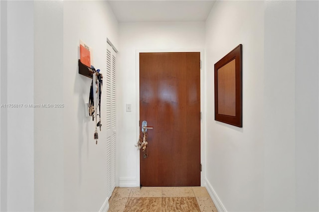 doorway featuring baseboards