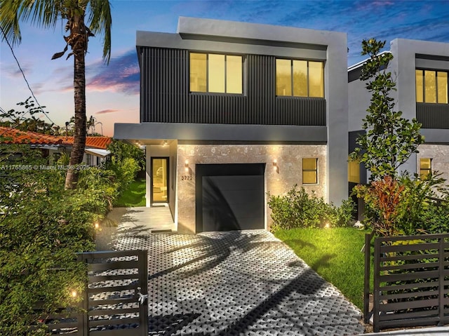 contemporary home with a garage, driveway, and stucco siding