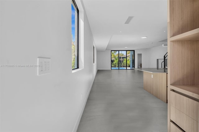 corridor with recessed lighting, visible vents, baseboards, stairway, and finished concrete floors