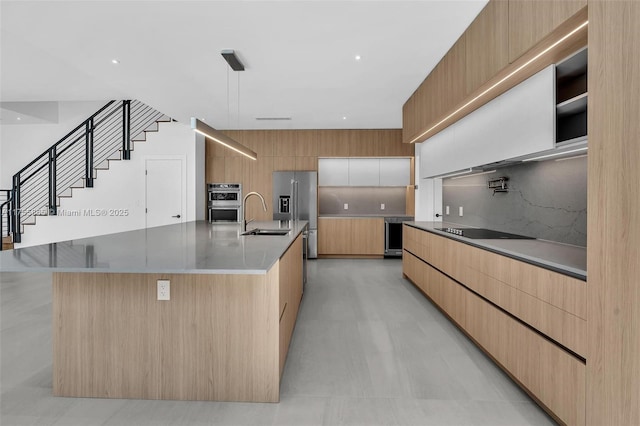 kitchen featuring pendant lighting, stainless steel appliances, tasteful backsplash, a sink, and modern cabinets