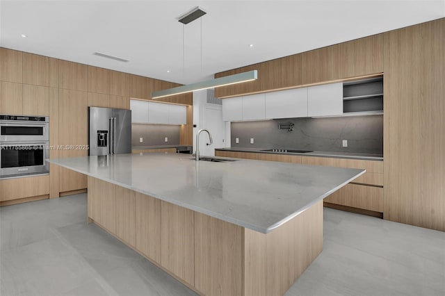 kitchen featuring stainless steel appliances, tasteful backsplash, modern cabinets, and a sink