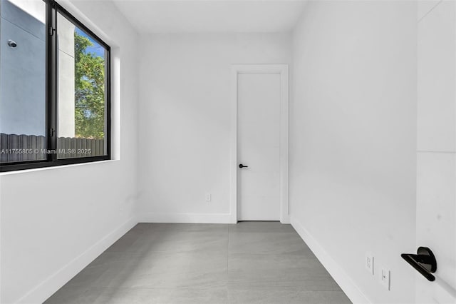 empty room featuring concrete flooring and baseboards