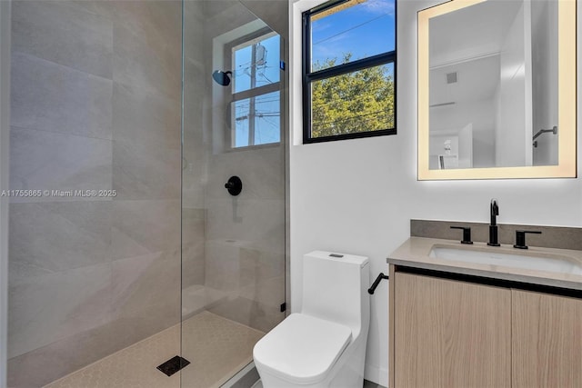 bathroom featuring visible vents, a tile shower, vanity, and toilet