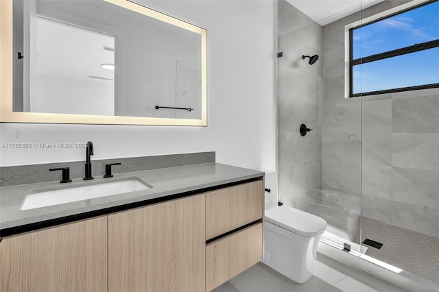 bathroom with tiled shower, vanity, and toilet