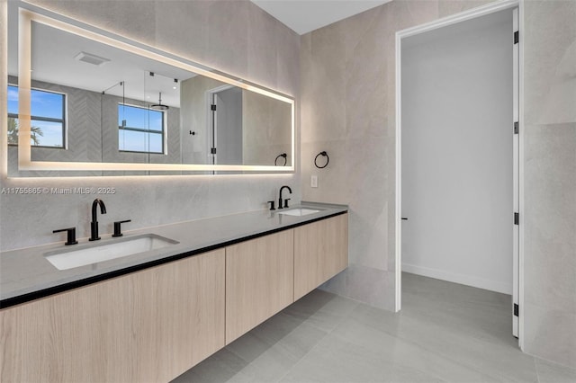 full bathroom featuring walk in shower, a sink, tile walls, and double vanity