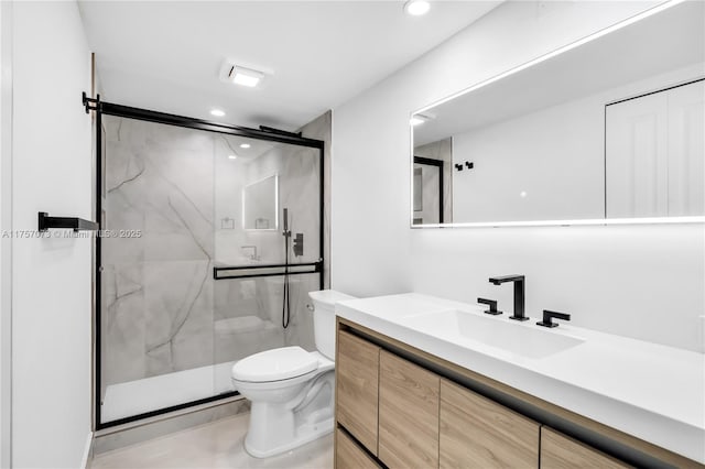 bathroom featuring toilet, recessed lighting, a marble finish shower, and vanity