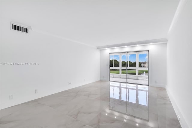 unfurnished room with marble finish floor, visible vents, crown molding, and baseboards