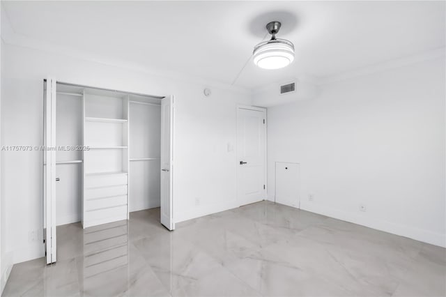 unfurnished bedroom with marble finish floor, visible vents, a closet, and ornamental molding